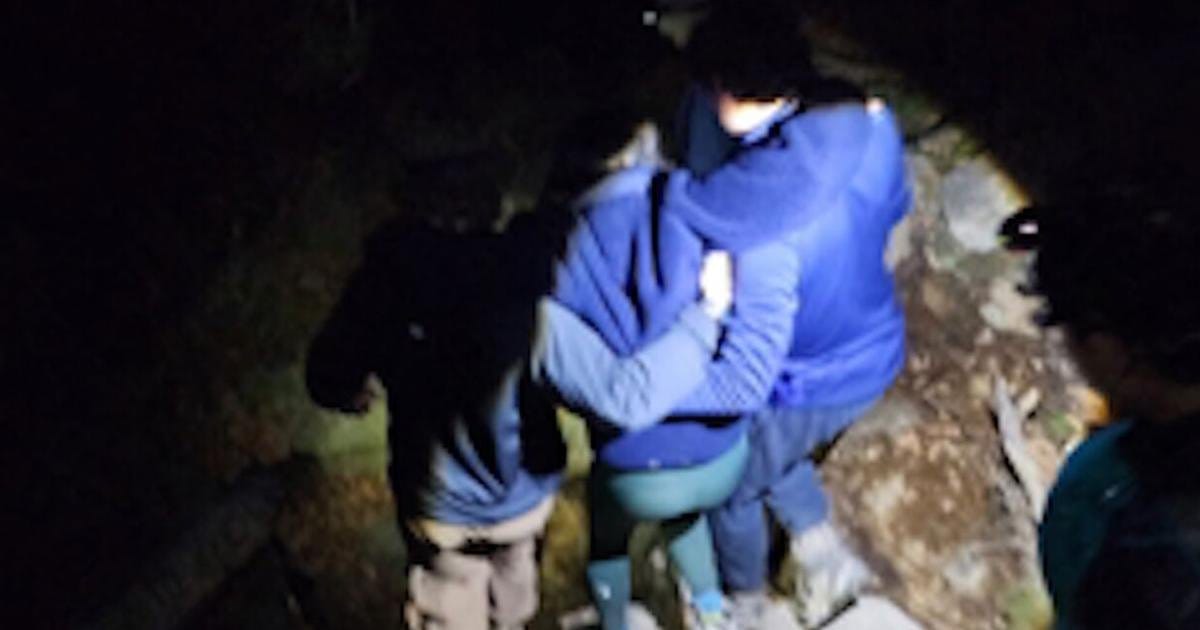 两名马什皮童子军将受伤的年轻女子抬下山